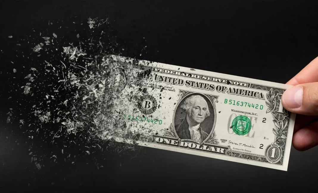 Le dollar américain à l’agonie, mauvaise nouvelle pour l’économie algérienne. Billet de dollar américain qui se désintègre dans la main.