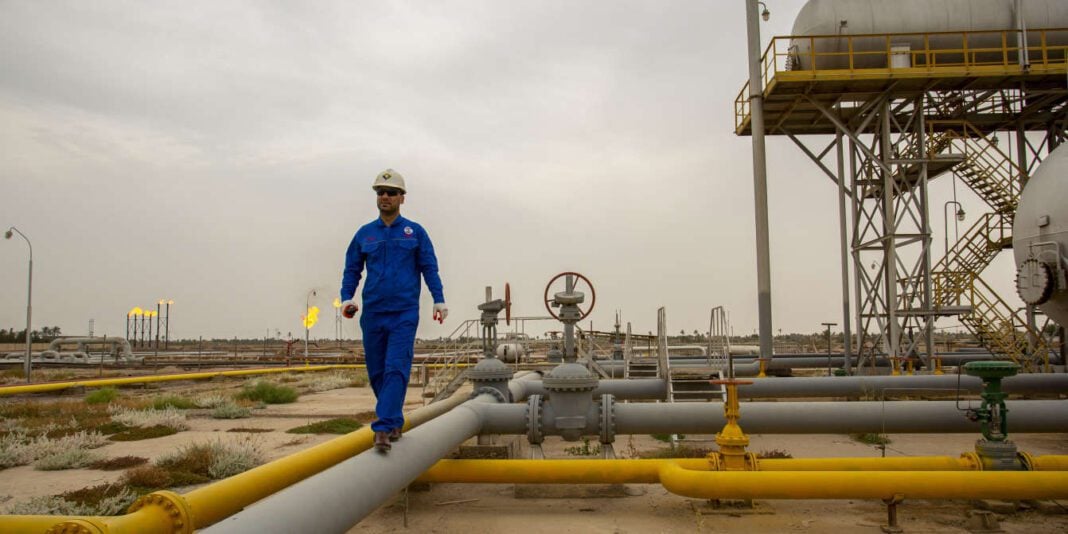 Ingénieur sur site pétrolier Ingénieur en combinaison bleue sur plateforme pétrolière en plein air.