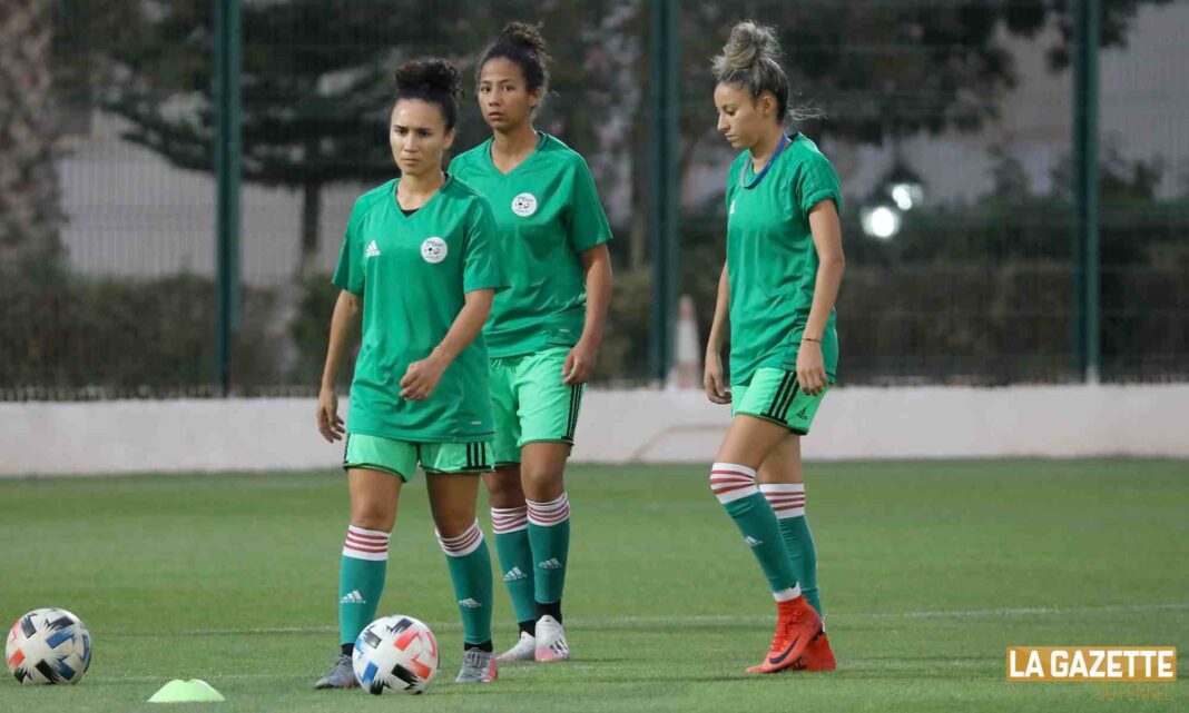 Trois joueuses de l'équipe féminine algérienne de football lors d'un entraînement.