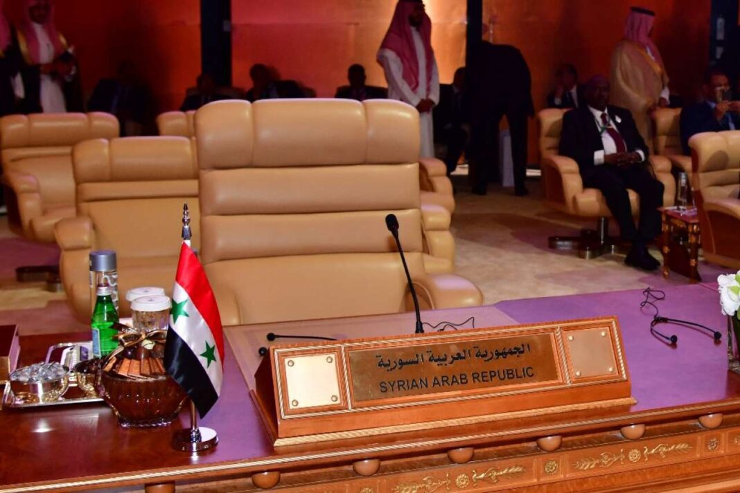 Salle de réunion avec un nom de table pour la Syrie et la Ligue arabe.