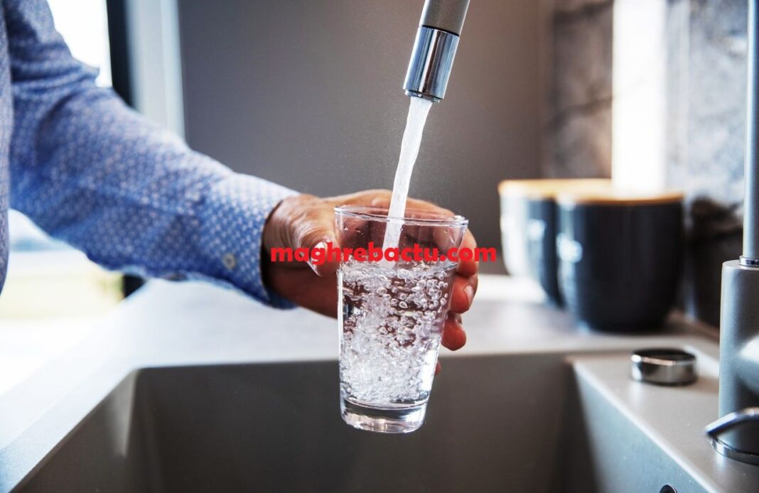 Eau potable contaminée par un pesticide Eau potable en train d'être filtrée dans un verre sous un robinet.