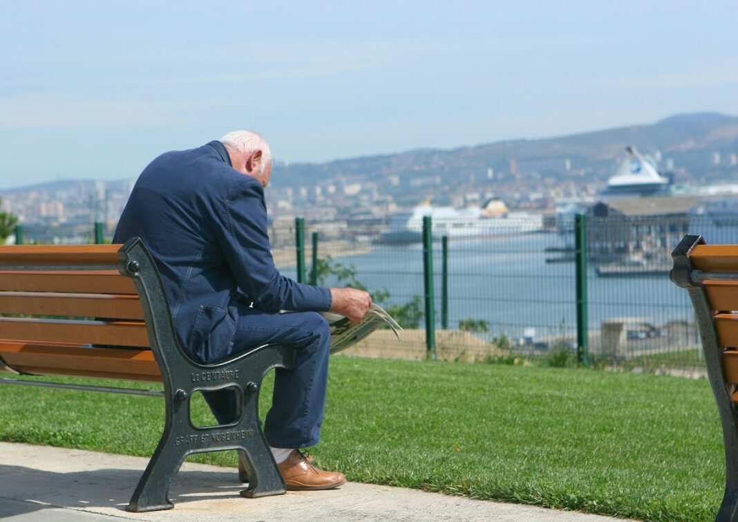 Retraites en France : Augmentation des pensions à partir de… Homme retraité regardant la mer depuis un parc en ville.
