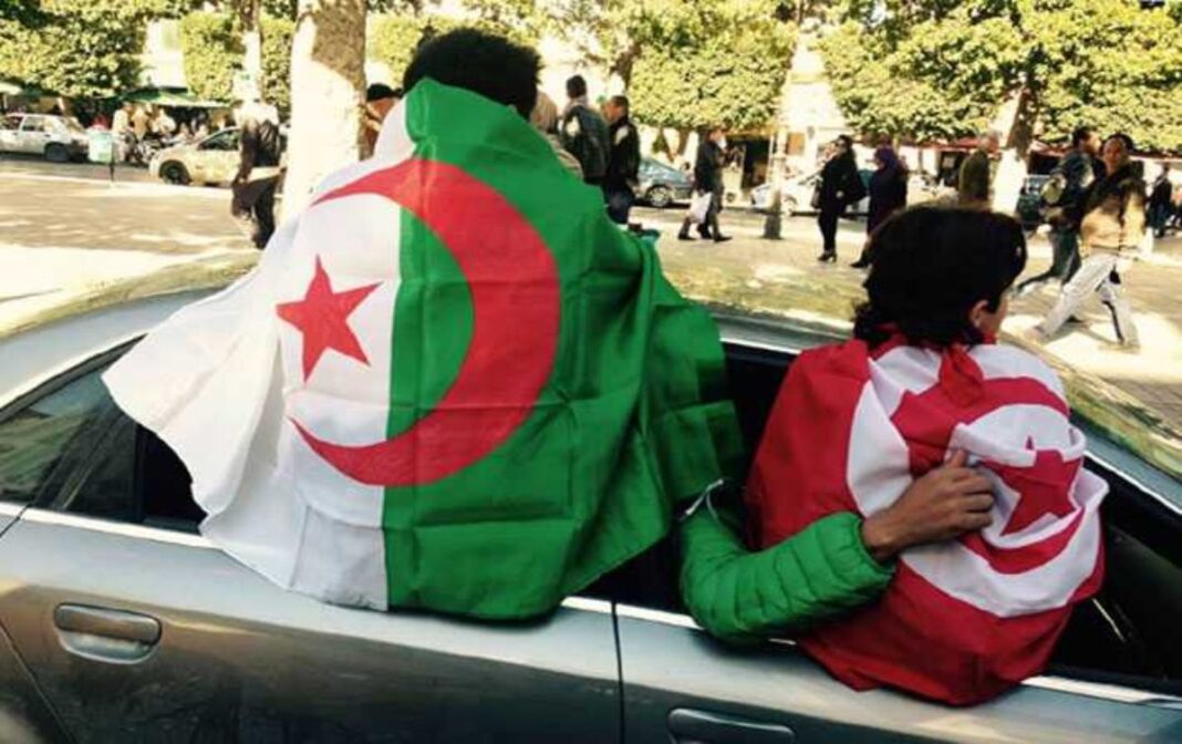 Tunisie : le nombre de touristes algériens bat le record au 1er trimestre 2023 Deux supporters algériens avec drapeaux lors d'un événement public.