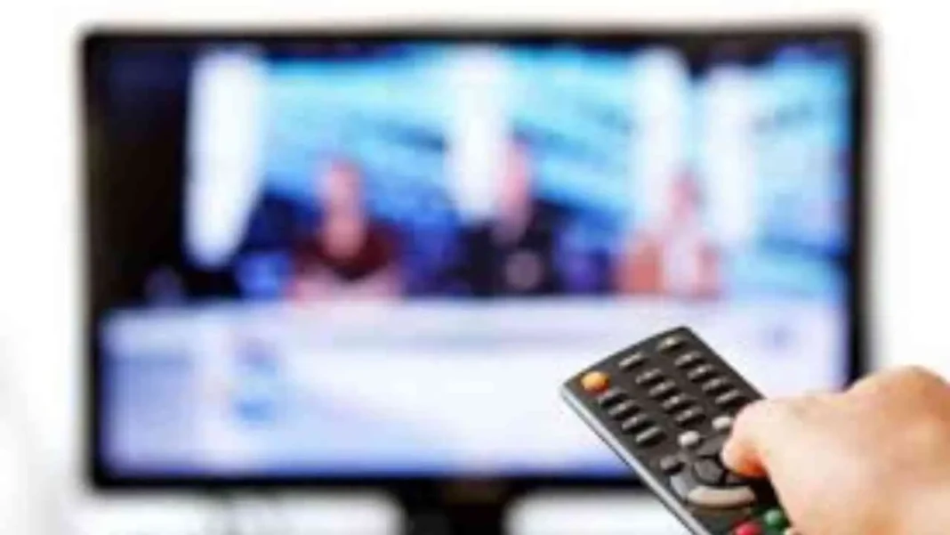 Personne utilisant une télécommande pour regarder la télévision en Algérie.