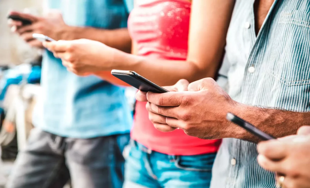 Lutte contre la tricherie aux examens du Bac : la coupure de l’internet agace les Algériens (Les autorités invitées à chercher autres méthodes) Groupe de personnes utilisant des smartphones en extérieur.