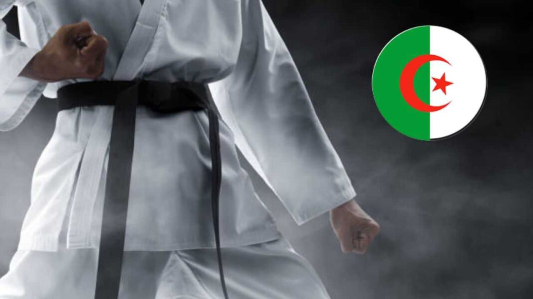 Karaté : l’Algérie talonne de très près le Japon, nation ayant inventé l’art martial. Pratiquant de karaté en uniforme avec drapeau algérien en arrière-plan.