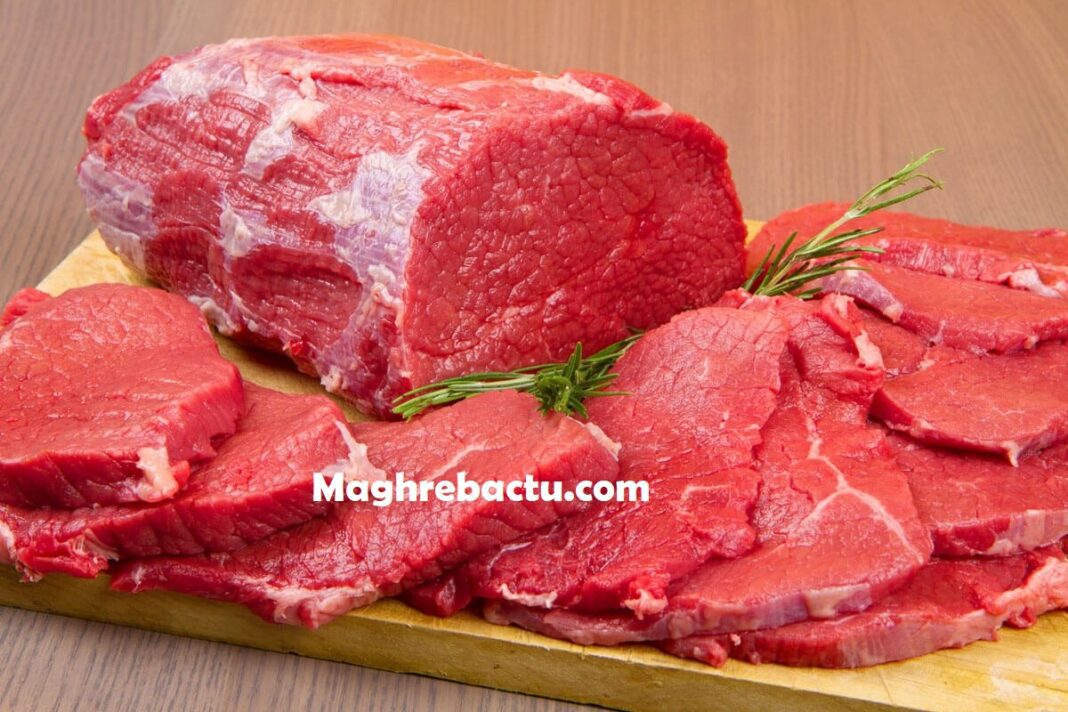 Viande de bœuf fraîche sur planche en bois, prête à cuisiner.
