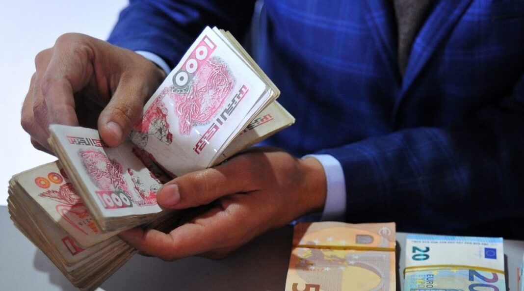 Banque d’Algérie et marché noir : Découvrez les cotations du dinar algérien ce 11 mai. Hommes tenant des billets de dinar algérien en main.