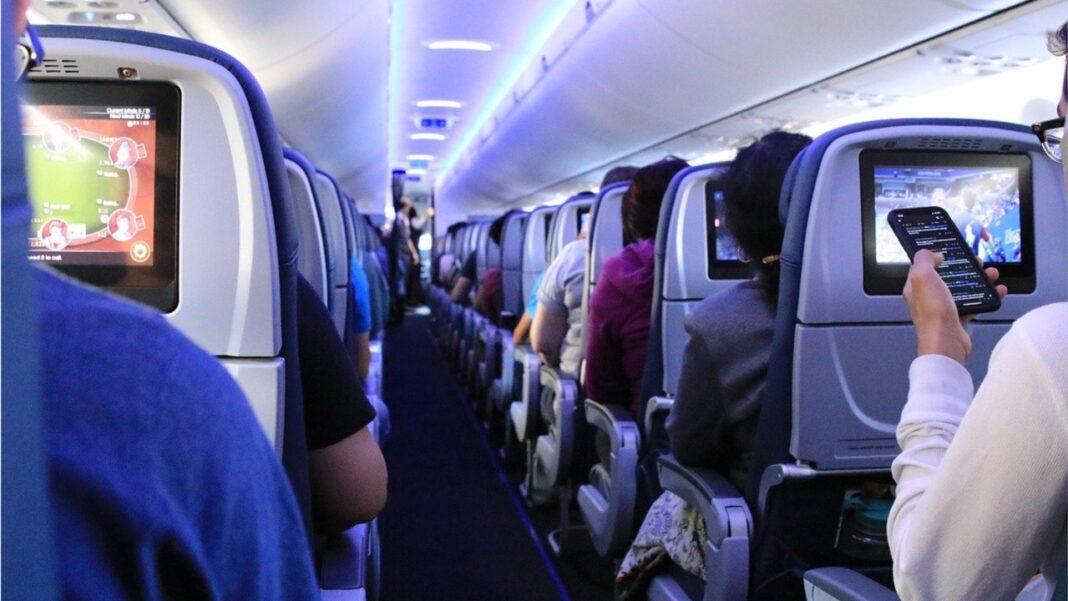 Passagers utilisant des écrans de divertissement en vol.