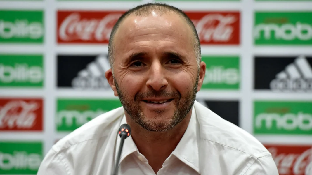Djamel Belmadi souriant lors d'une conférence de presse sportive.