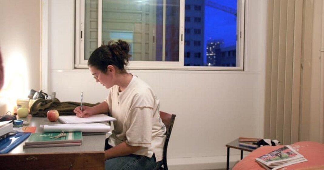 Jeux Olympiques 2024 : Les étudiants sommés de quitter les logements CROUS. Femme étudiante travaillant à son bureau à domicile en soirée.