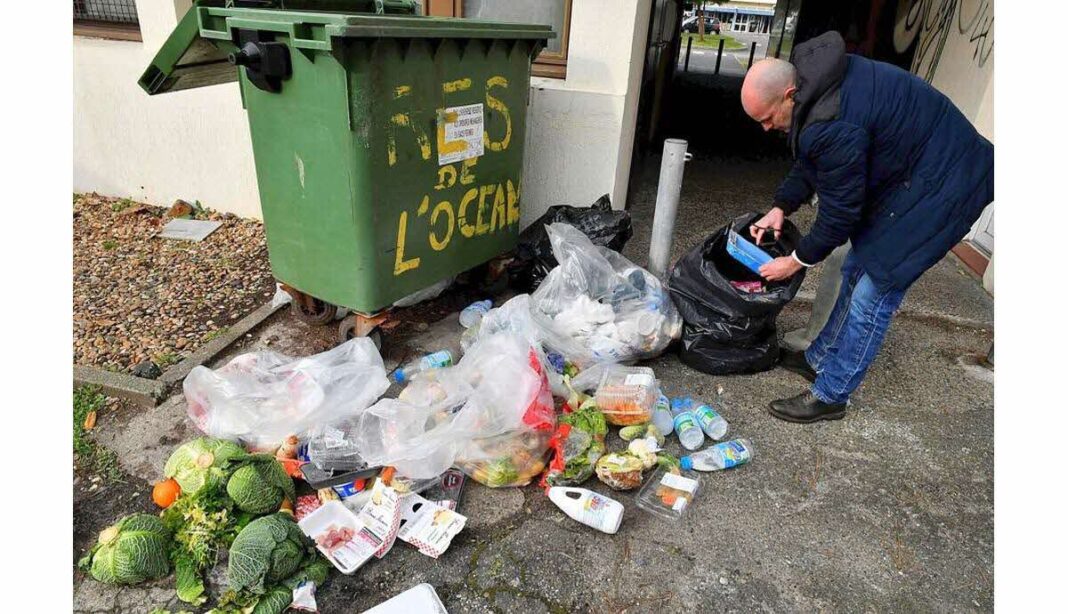 Homme jetant des déchets alimentaires dans une poubelle.