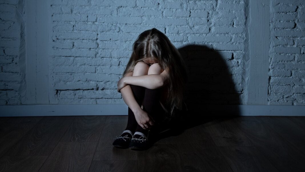 Ça n’en finit pas ! Encore un autre cadre du Maroc, impliqué dans un scandale sexuel. Jeune fille assise par terre, visage caché, dans une ambiance sombre et isolée.