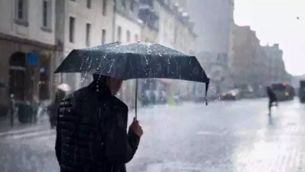 Bulletin spécial : Orages violents jusqu’à 50 mm dans 16 États Personne avec parapluie sous forte pluie en ville.