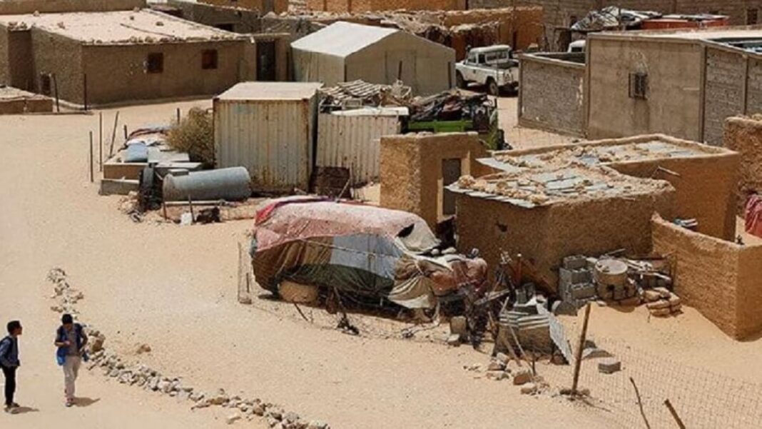 Un ressortissant espagnol arrêté par le Polisario Village saharien avec habitations en terre et véhicules dans le désert.