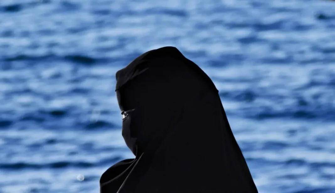Voleur déguisé en « jilbab » : Arrestation dans des bijouteries à Oran Femme portant un jilbab noir près de l'eau.