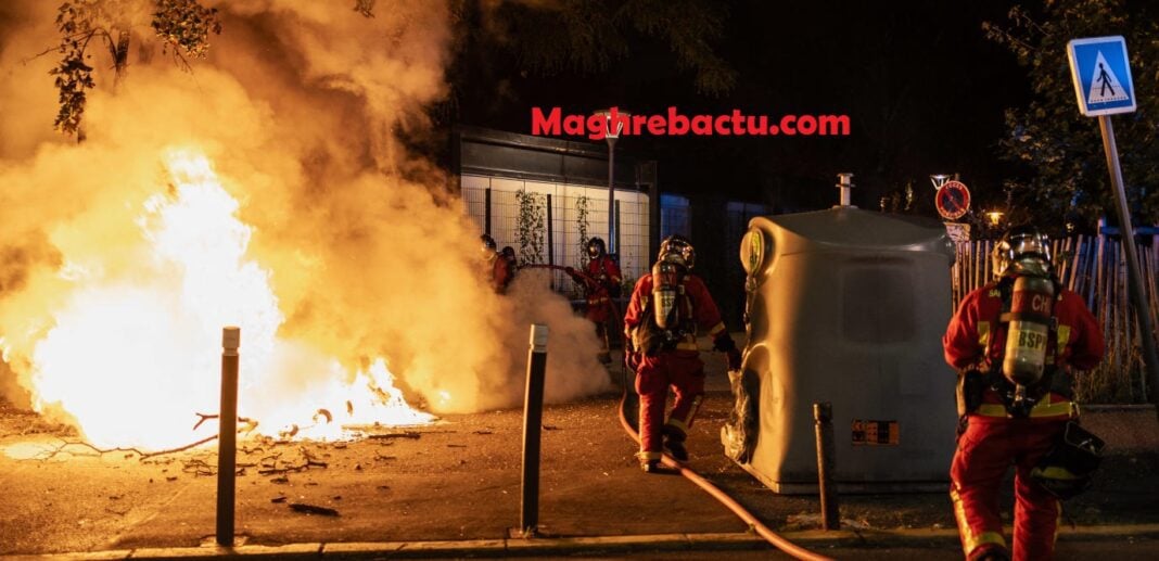 Mort de Nahel : Arrêt des bus et tramways dans toute la France après 21 heures Pompiers éteignant un feu lors d'une manifestation nocturne en France.