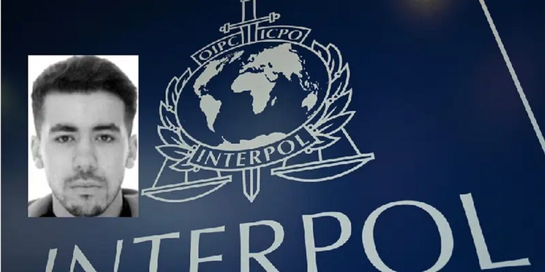 Guinée : Ibrahim akhlal, le braqueur belgo-marocain réalise son prison break ( Il s’évade pour la deuxième fois) Photo d'Ibrahim Akhlal avec logo d'Interpol en arrière-plan.