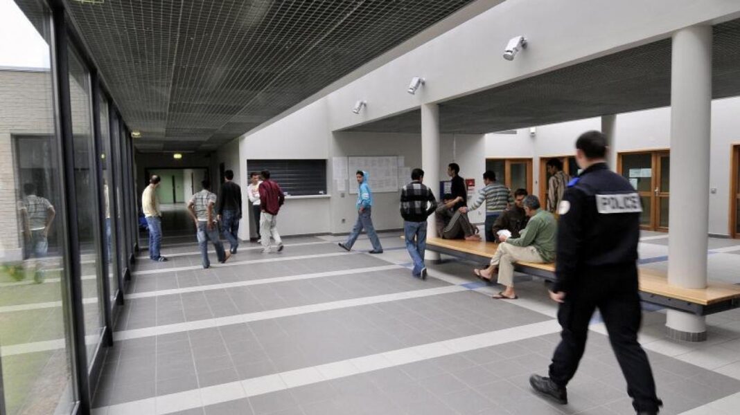 France : un imam algérien expulsé Policiers et personnes dans un hall d'entrée en France.