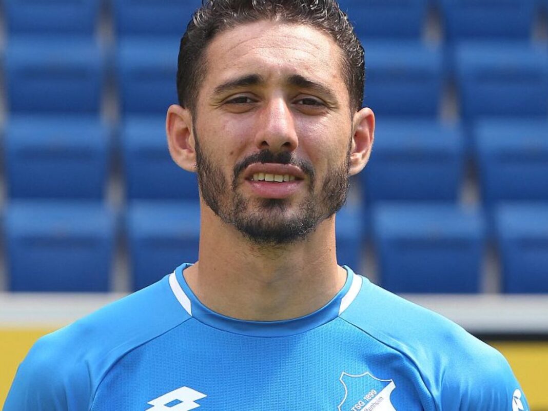 Footballeur professionnel en action Joueur de football en maillot bleu sur le terrain.