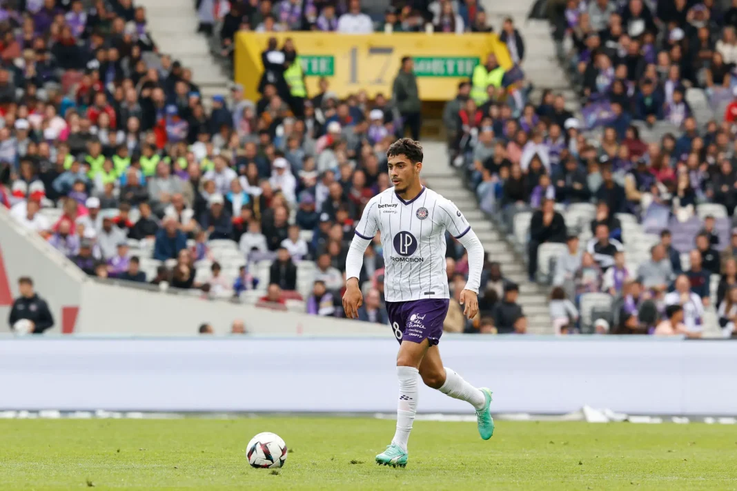 Mercato 2023 : Farès Chaïbi en route pour la Bundesliga ? Découvrez. Farès Chaïbi joue au football sur le terrain avec un public en arrière-plan.
