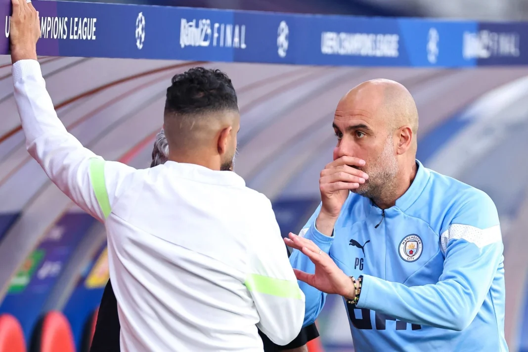 Guardiola parle à Mahrez lors d'un entraînement de football.