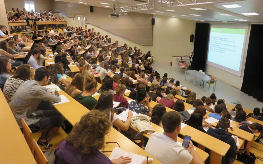 Conférence universitaire en grand amphithéâtre Étudiants attentifs lors d'une conférence dans un grand amphithéâtre.