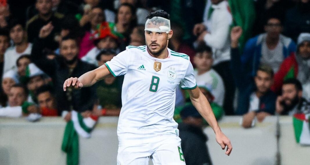 Youcef Belaïli, joueur algérien, en pleine action sur le terrain de football.