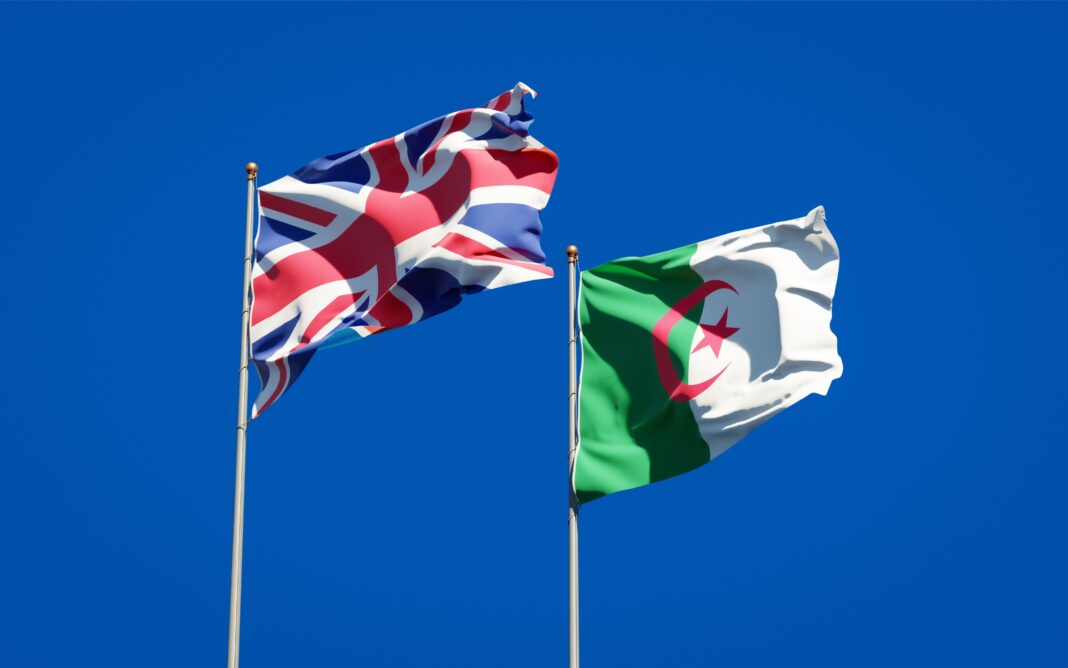 Drapeaux du Royaume-Uni et d'Algérie Drapeaux du Royaume-Uni et d'Algérie flottant dans le ciel bleu.