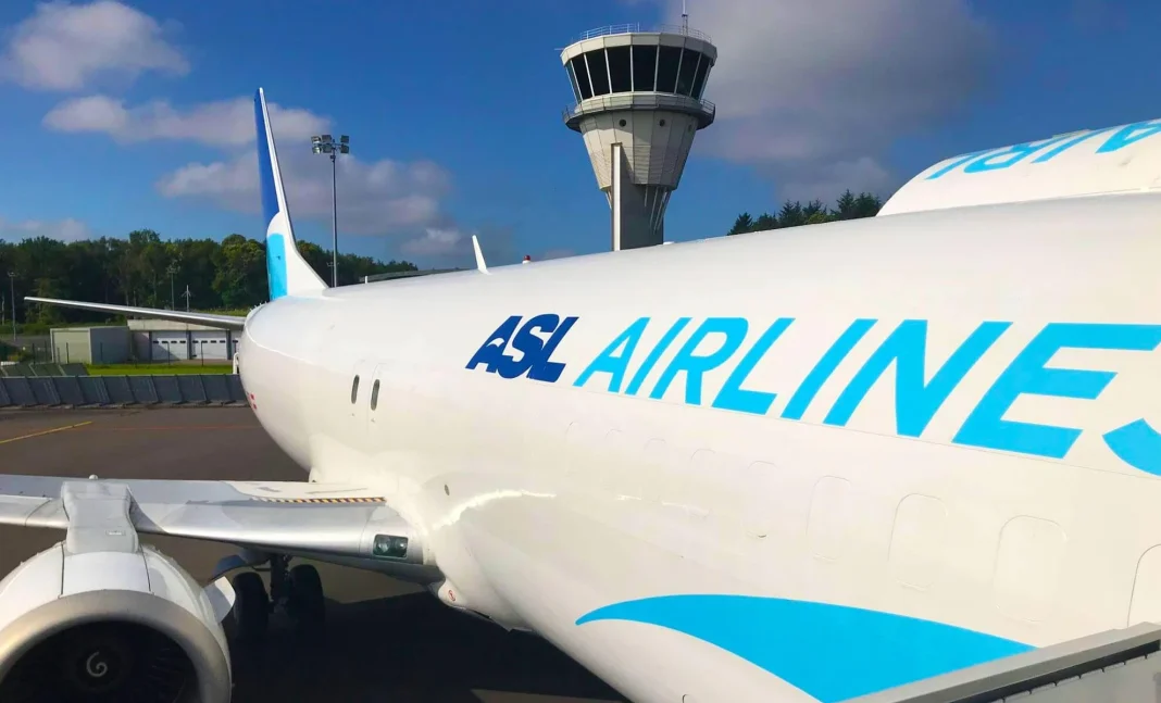 Avion d'ASL Airlines à l'aéroport Avion d'ASL Airlines prêt pour le vol, vue de côté avec tour de contrôle en arrière-plan.