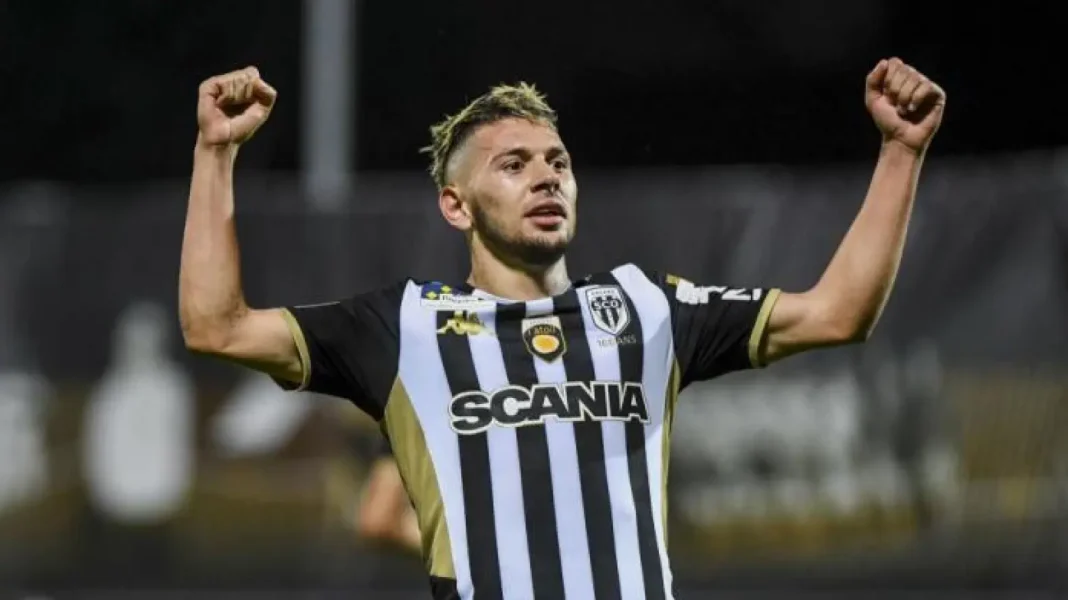 Voici le remplaçant de Mahrez selon Madjer Footballeur célébrant avec bras levés, portant maillot noir et blanc.