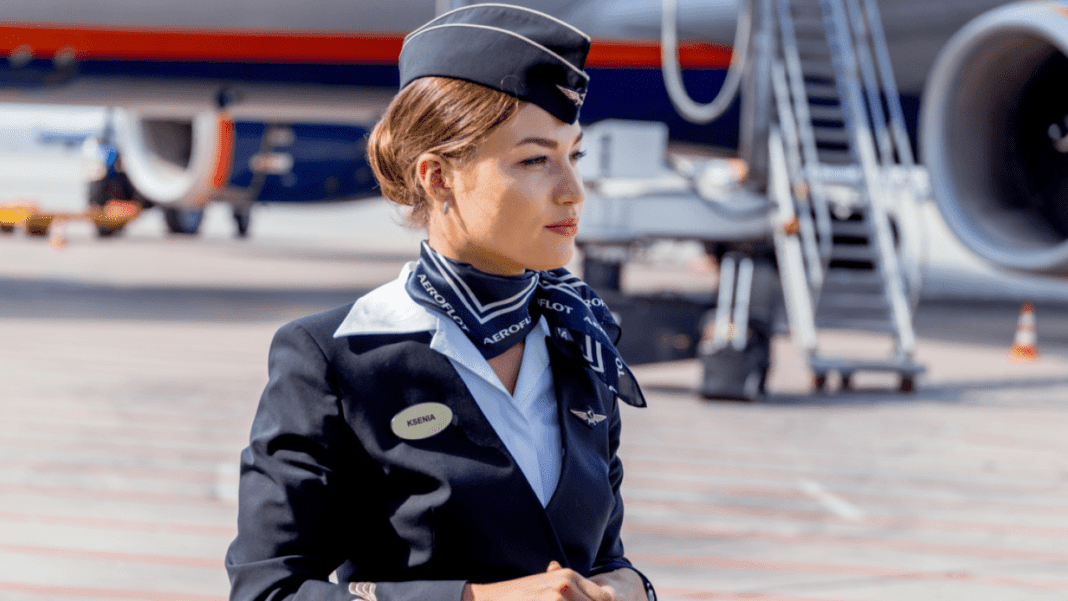Voici les critères de recrutement pour devenir hôtesse de l’air Hôtesse de l'air professionnelle en uniforme à l'aéroport.