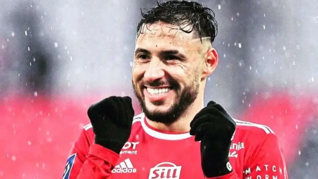 Youcef Belaili au MCA : la Ligue 1 Uber Eats sort du silence Youcef Belaïli souriant en tenue de football sous la pluie.