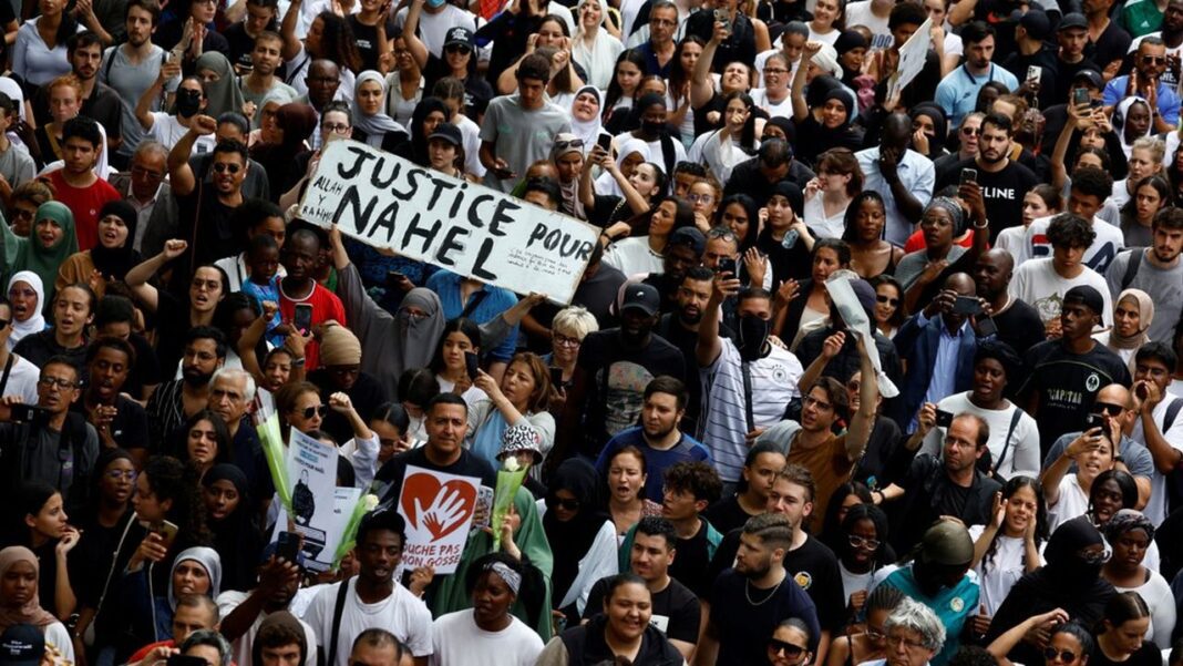 Affaire « mort de Nahel » en France : enquête clôturée, mais des doutes persistent Rassemblement massif pour Nahel avec pancarte Justice pour Nahel.