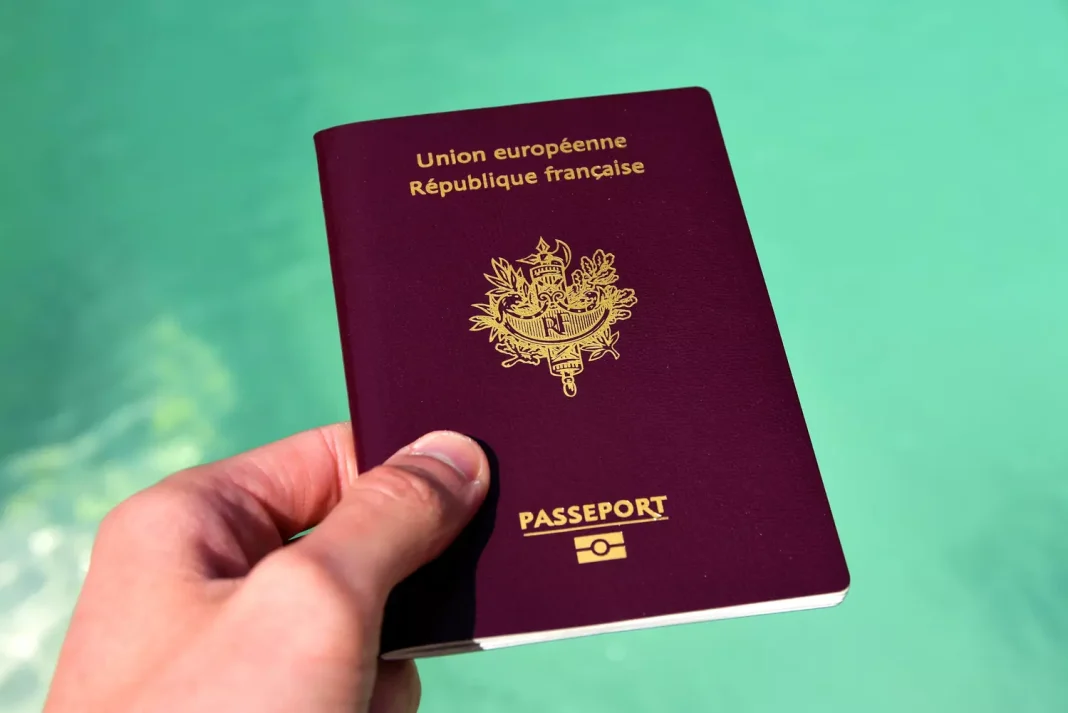 Comment renouveler facilement et rapidement votre passeport en France ? Passeport français de l'Union européenne en main.