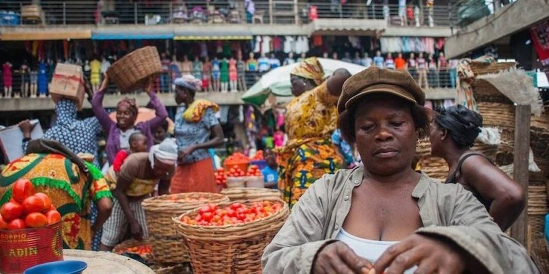 Femme dans un marché informel avec vendeurs et acheteurs.