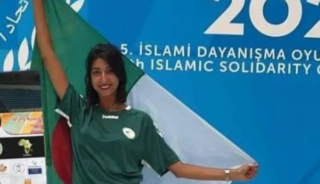 Jeux Arabe… Basma Boukernafa renverse la marocaine Sarah El Idrissi Athlète féminine en tenue verte avec drapeau lors des Jeux Arabes.