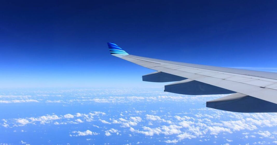 Enfin ! Bonne nouvelle à propos des vols annulés Aile d'avion en vol avec ciel bleu et nuages en dessous.