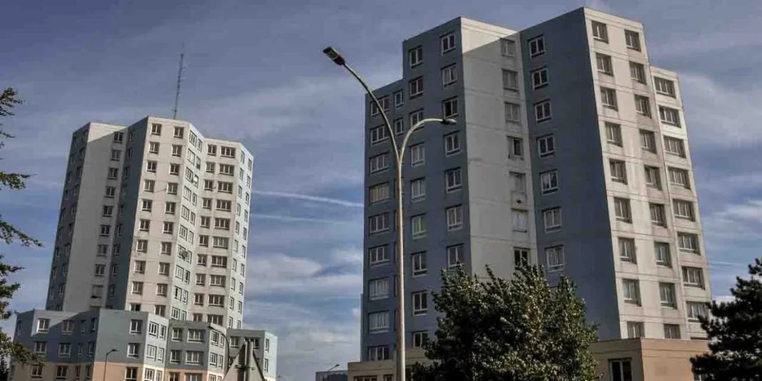 Deux immeubles résidentiels modernes sous un ciel nuageux en France.