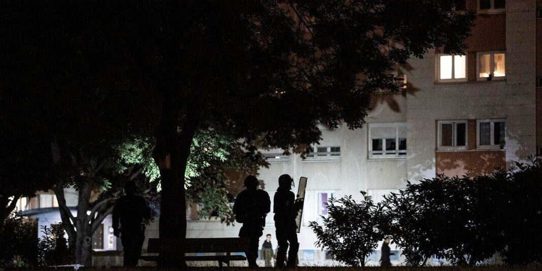 Emeutes après la mort de Nahel : vers un retour au calme en France Manifestants dans une rue sombre pendant les émeutes en France.