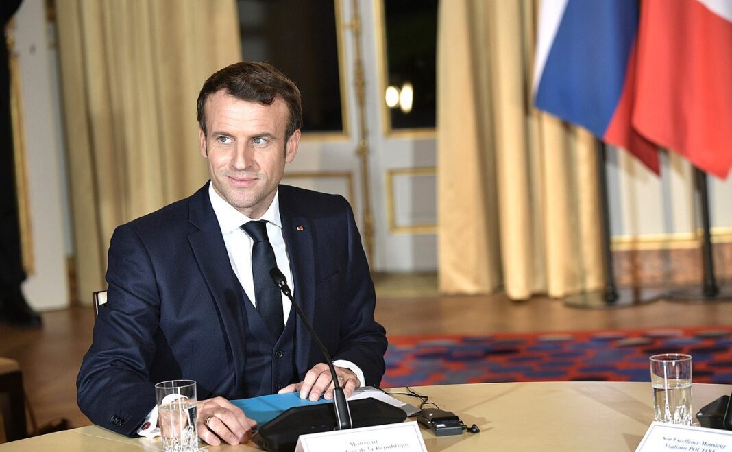 Un « doigt coupé » sur le bureau de Macron : L’Elysée sous le choc Emmanuel Macron assis à une table lors d'une conférence officielle.
