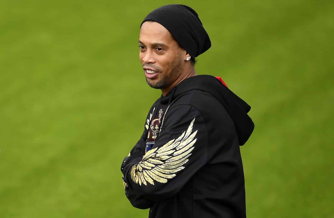 Ronaldinho portant un bonnet noir et un sweat à capuche avec des ailes dorées.