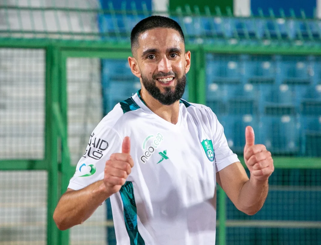 Ryad Boudebouz souhaite la bienvenue à Riyad Mahrez à Al-Ahli Riyad Mahrez en maillot d'Al-Ahli, souriant et faisant un geste de victoire.