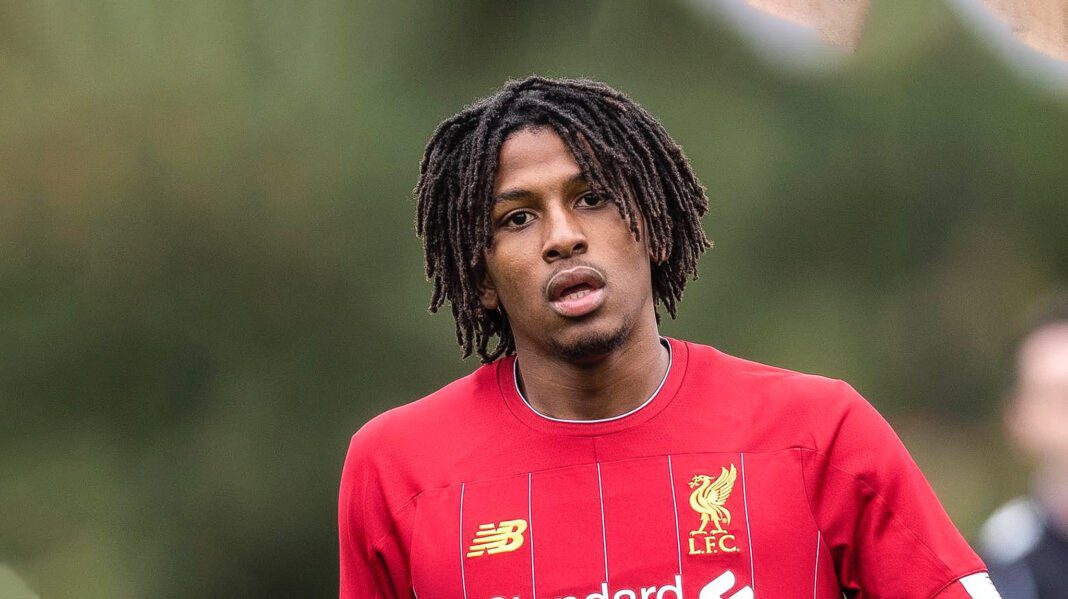 Yasser Larouci à la porte de l'équipe d'Algérie Yasser Larouci en maillot de football rouge, portrait en plein air.