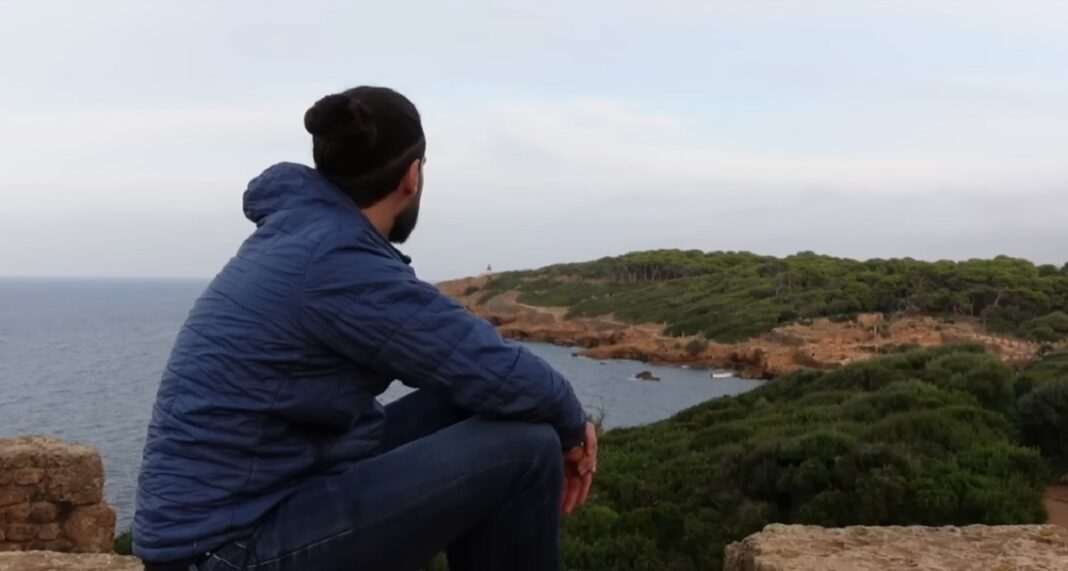 Visite en Algérie : Découvrez l’incroyable témoignage de ce touriste français (Vidéo) Homme regardant la mer et la côte en Algérie.