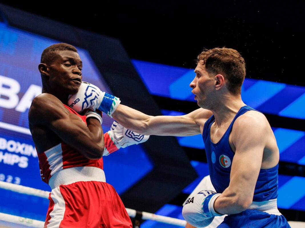 Jeux sportifs arabes : le boxeur algérien Kramou remporte la médaille d’or Deux boxeurs en combat lors des Jeux sportifs arabes, un en rouge et l'autre en bleu.