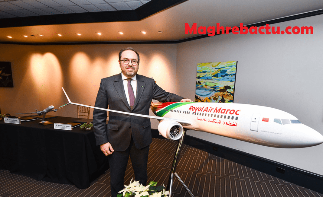 Homme en costume devant un modèle réduit d'avion Royal Air Maroc.