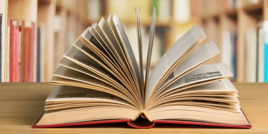 Livre ouvert avec pages tournées, bibliothèque en arrière-plan.