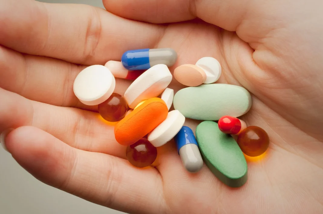 Médicaments en main pour traitement Pilules et capsules variées pour traitement médical.