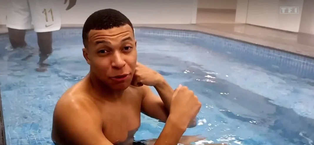 Kylian Mbappé en piscine avec une Top modèle Kylian Mbappé dans une piscine, regardant l'objectif, ambiance détendue.